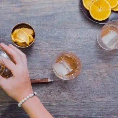 Top view of a woman's hands combining different cocktail ingredients to create easy 2 ingredient cocktails