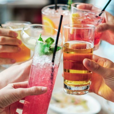 Image of hands raising glasses of 3 ingredient cocktails