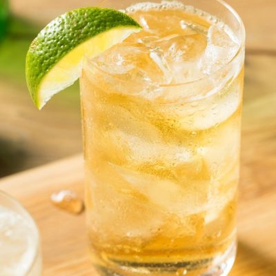 Close-up of Rock Shandy in Highball glass filled with ice and garnished with lime wedge