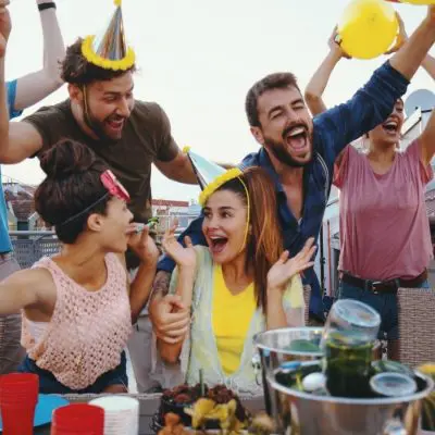 Close-up group shot of a bunch of friends having a great time at a DIY at-home birthday party