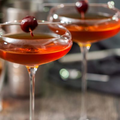 Two classic Manhattan cocktails with maraschino cherry