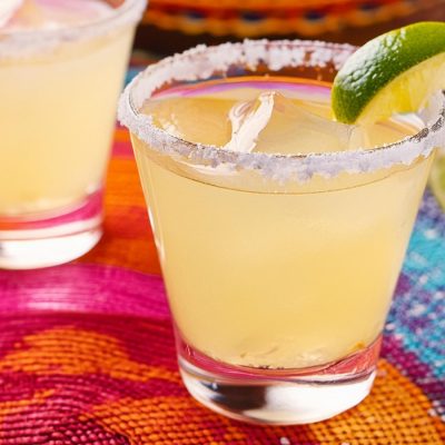 Two Mezcal Margarita cocktails served on a colourful Mexican-themed placemat