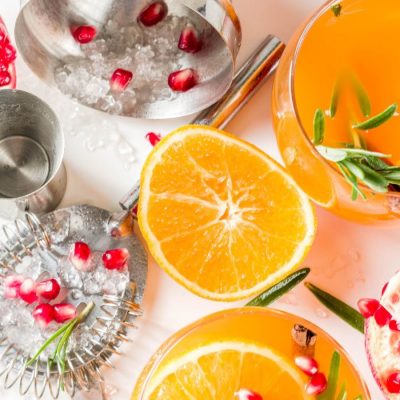 Orange juice cocktails with pomegranate and rosemary