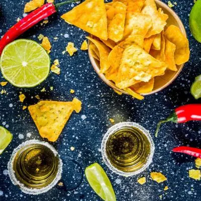 Top shot of mezcal shots and nachos