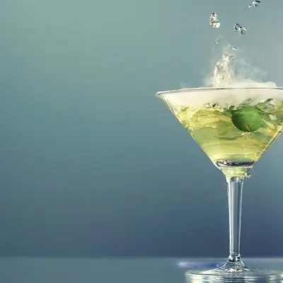 Smoking dry ice dirty martini with green olive garnish