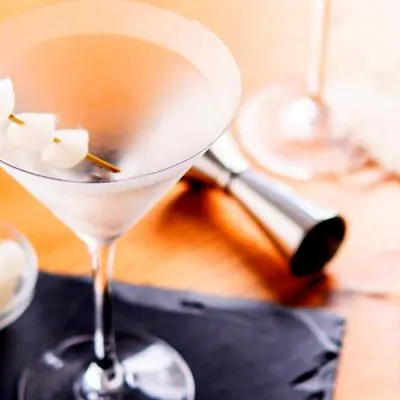 Top view of a pair of Gibson Martinis with skewered cocktail onion garnishes on a wooden surface