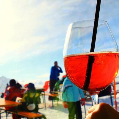 Close-up of an Aperol Spritz against a ski resort backdrop