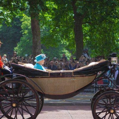 The Queen in a carriage on a sunny day