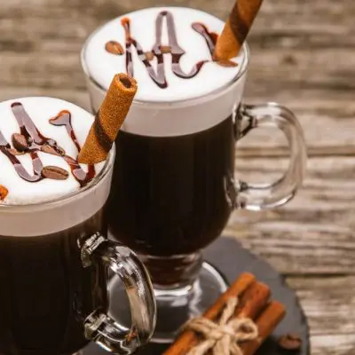 Two Irish coffees in glasses on wood