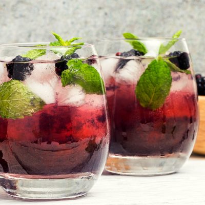 Blackberry shrub cocktails with mint garnish