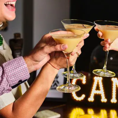 Friends enjoying clinking eggnog martinis togeher