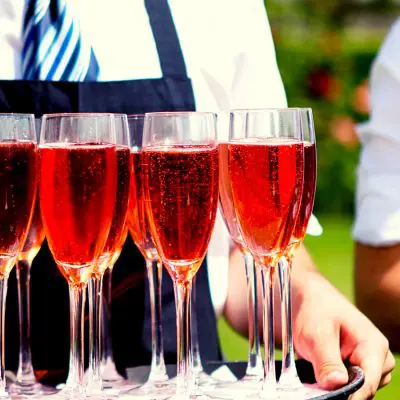 Waiter serving red wedding cocktails