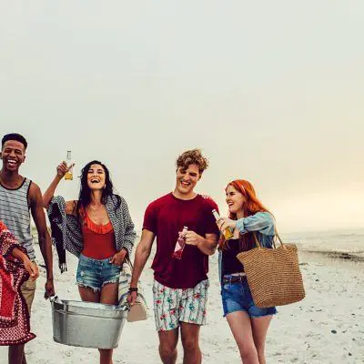 Friends carrying cooler boxes to a BYOB party