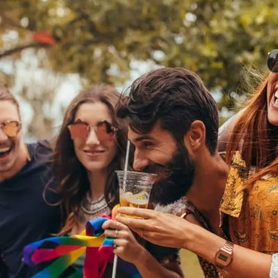 Friends laughing and enjoying camping cocktails at a music festival