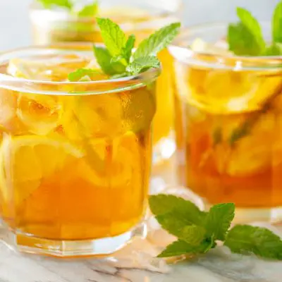 Three Vodka Iced Tea cocktails in tumblers with lemon and mint garnish