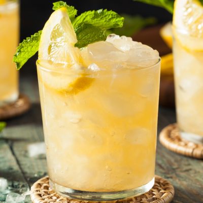 Classic Whiskey Smash cocktails with lemon and mint garnish