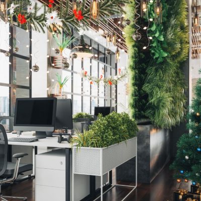 Christmas party decorations set up in a bright, light modern office space, including a big tree
