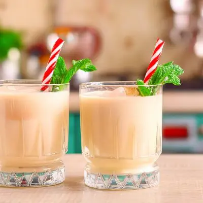 Two Peppermint White Russian mocktails with candy cane and mint garnish