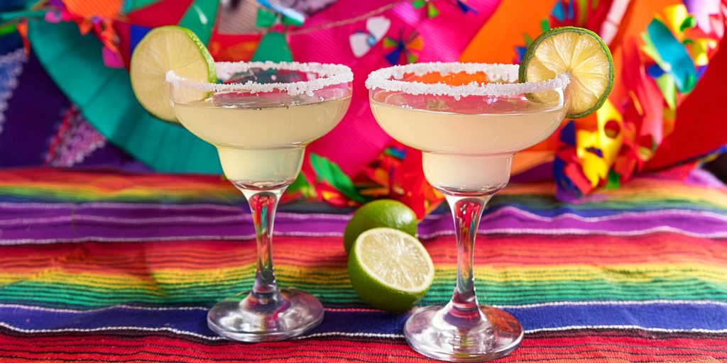 Two Grand Margarita Cocktails with salt rims and lime wheel garnish