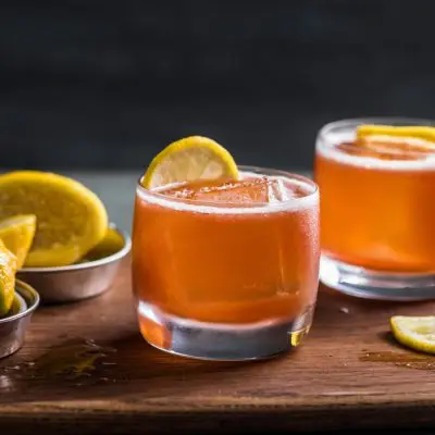 Two Paper Plane cocktails on the rocks with lime wheel garnish