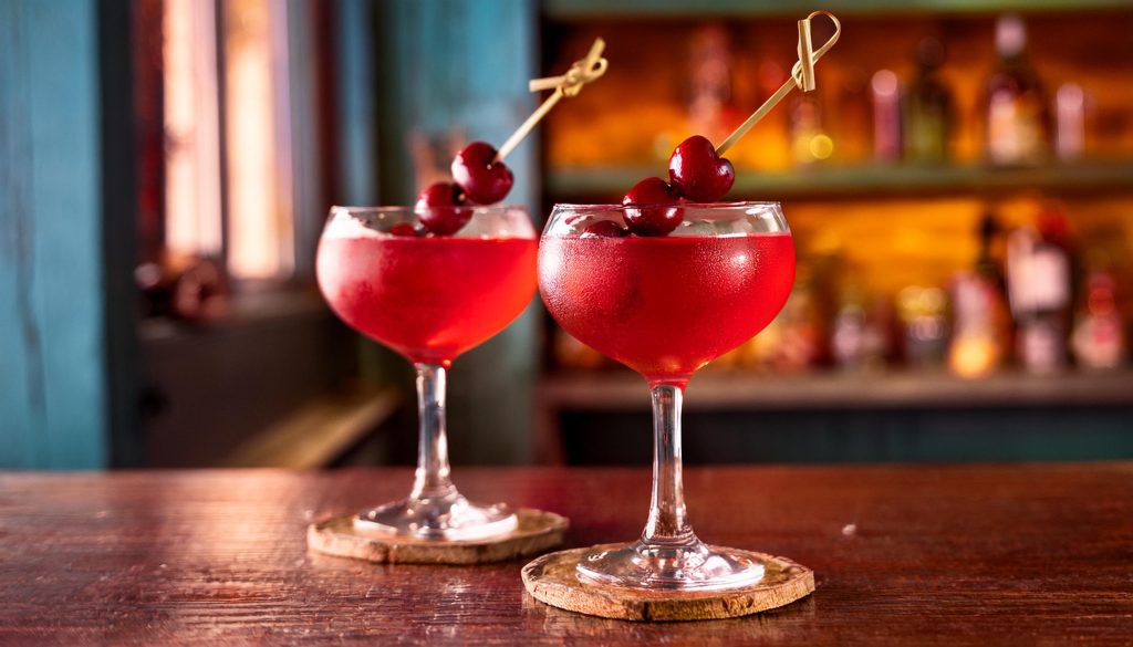 Two red Mary Pickford cocktails with cherry garnish