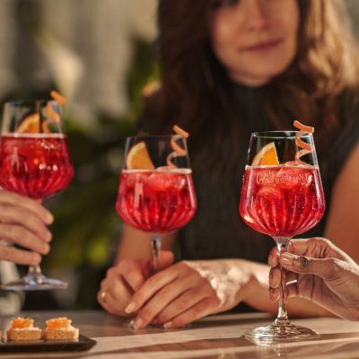 Three people enjoying Campari Spritz cocktails