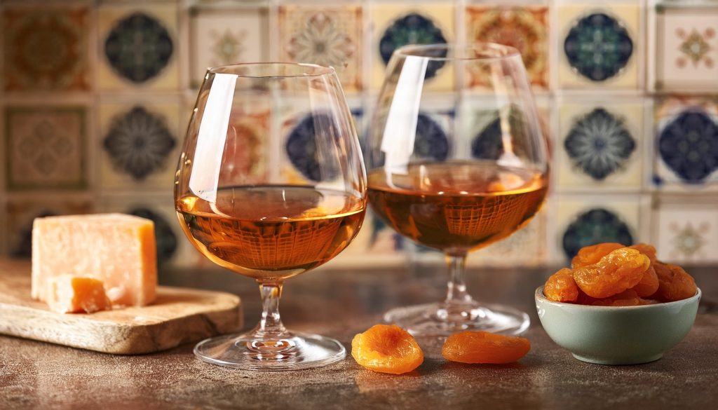 Two glasses of Armagnac served with dried apricots and aged parmesan 