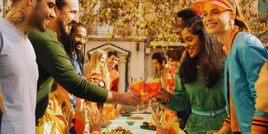 Friends enjoying Venetian Aperitivo Hour with Aperol Spritz cocktails in an outdoor setting in a piazza