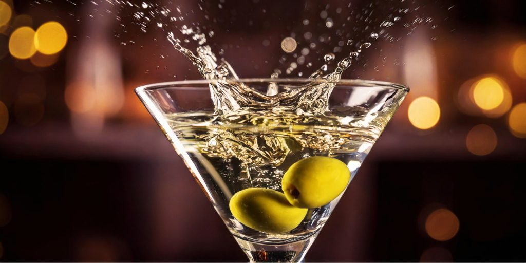 A close-up shot of olives splashing into a Dirty Martini