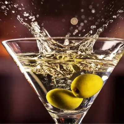 A close-up shot of olives splashing into a Dirty Martini