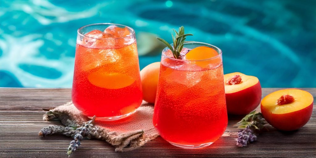 Two Sparkling Peach Sunrise mocktails served poolside