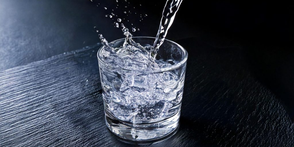 A close-up of Espolòn Cristalino being poured into a rocks glass filled with ice