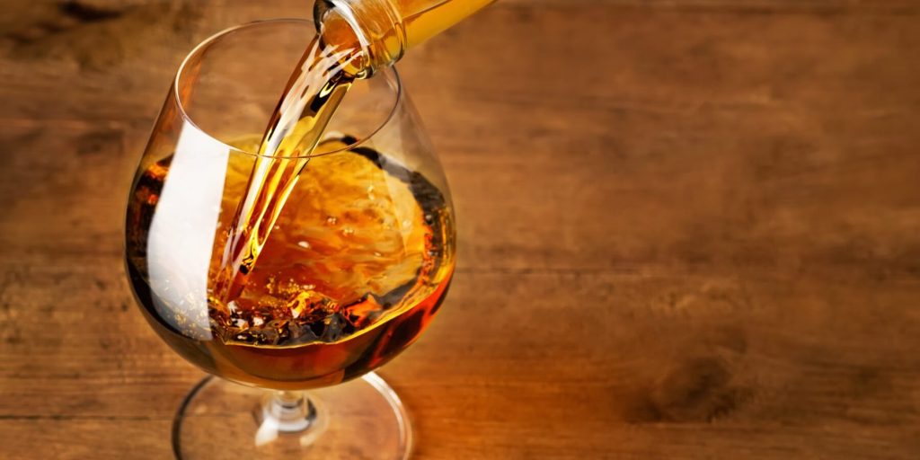 Close-up of cognac being poured into a glass, photo by alter_photo