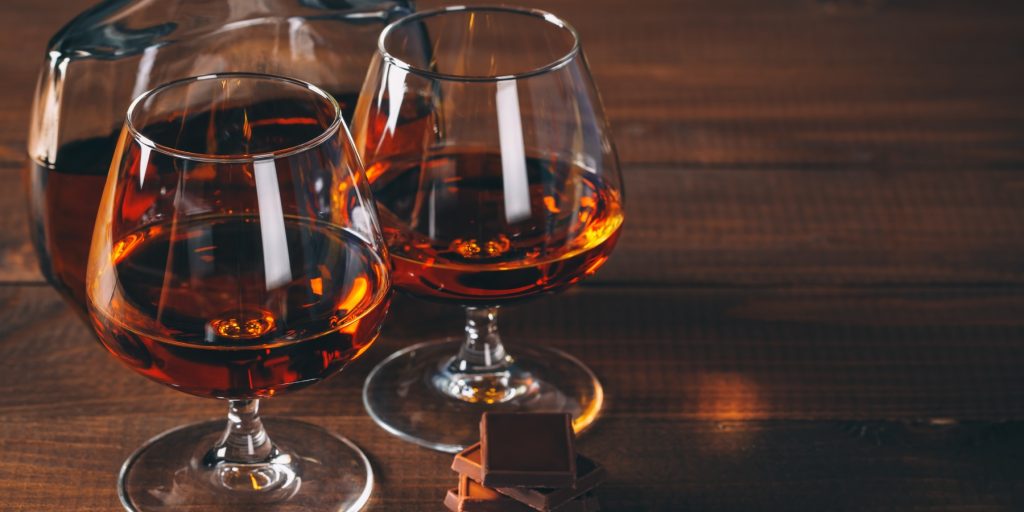 Close up of two glasses of cognac paired with dark chocolate, photo by EdNurg