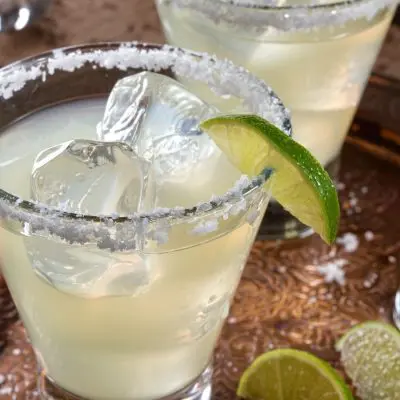 Margarita on a metal tray with limes