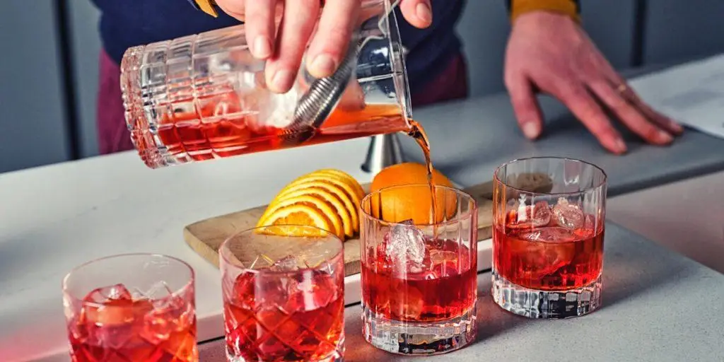 Pouring shot of on the rocks Negroni cocktails