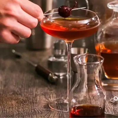 French Manhattan Cocktail with Maraschino cherry garnish on wooden table