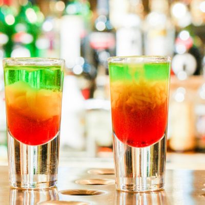 A row of four green, yellow and red Squashed Frog cocktails