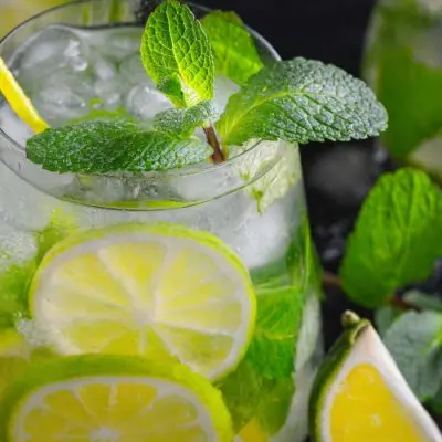 Virgin Mojito with a yellow straw, mint and sliced lime