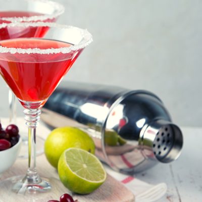 Two bright red Cranberry Martinis with lime and fresh cranberries