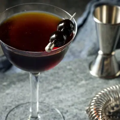 A Black Manhattan cocktail garnished with a cherry