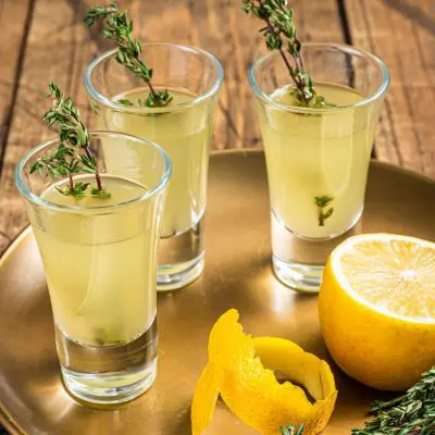 An invigorating Green Tea Shot recipe served up with a thyme garnish for extra flavor