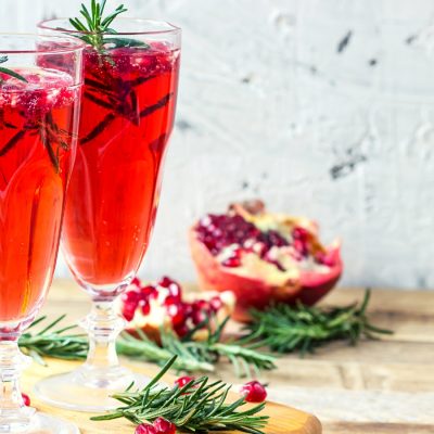 Bright red Cranberry Mimosa with pomegranate garnish