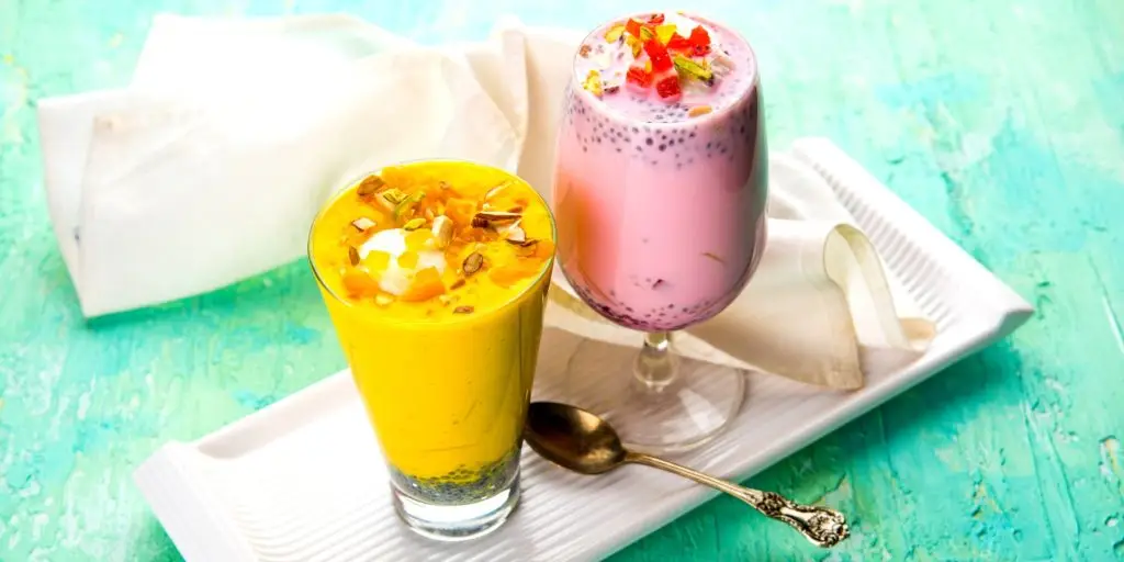 Traditional Indian falooda dessert drinks on a white plate against a turquoise background