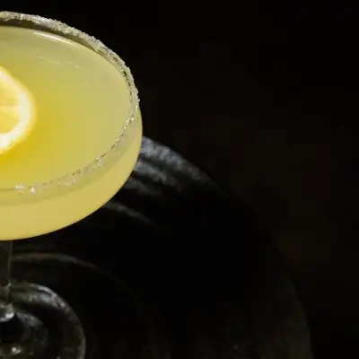 A Mad Hatter cocktail garnished with lemon