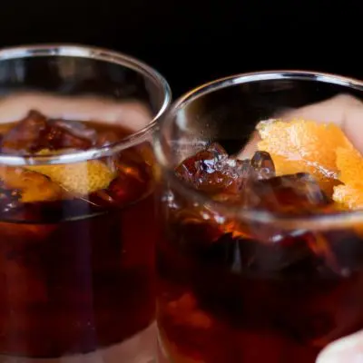 Two friends toasting with rye whiskey cocktails