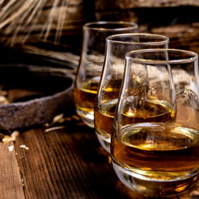 Three glasses of Scotch on a wooden table