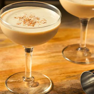 Creamy Golden Cadillac cocktails in coupe glasses served with a sprinkling of nutmeg