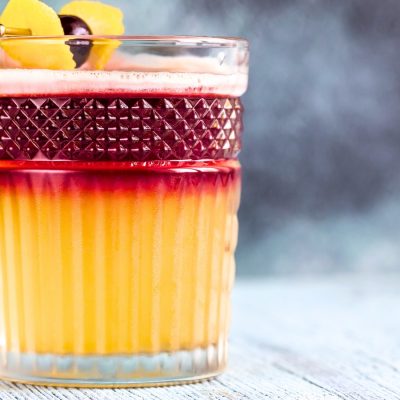 Cherry Point Sour cocktail with a lemon twist and cherry garnish
