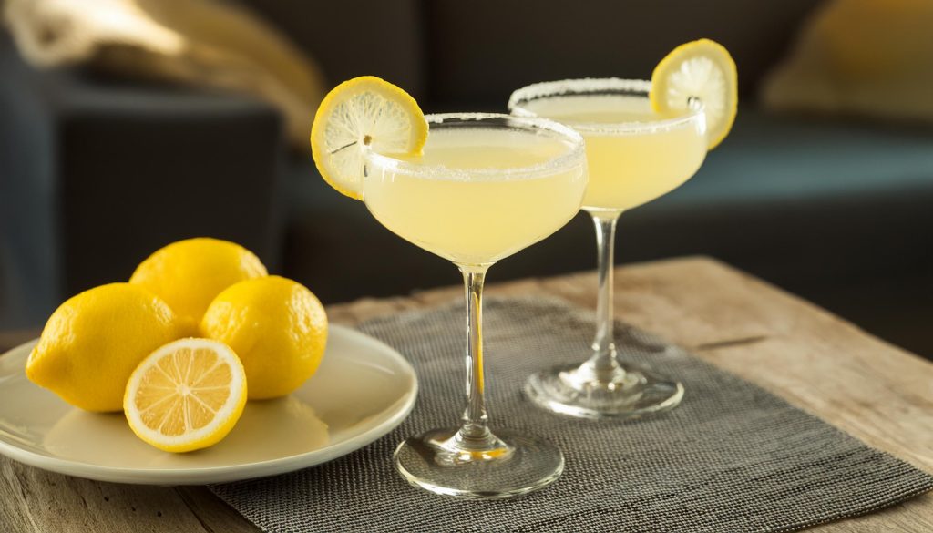 Two Vodka Sidecar cocktails in coupe glasses with sugar rims and lemon wheel garnishes
